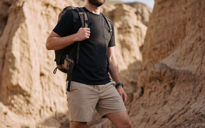 Man hiking with backpack wearing men's performance tee with pocket and performance khaki shorts